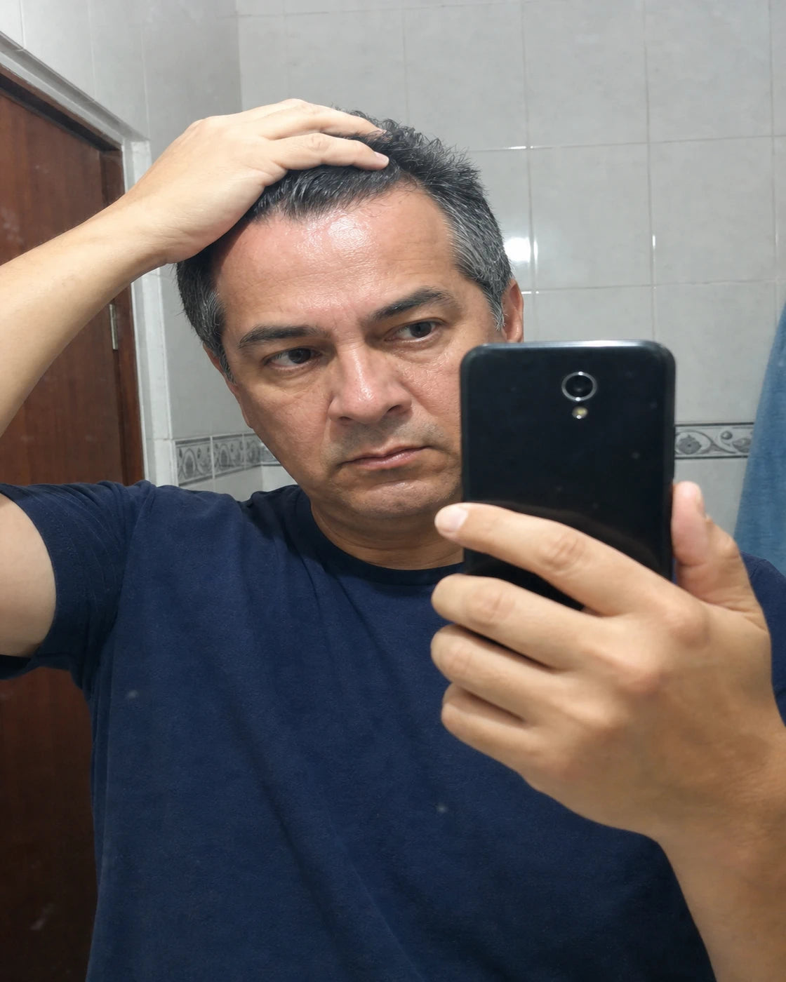 Roberto mostrando su cabello frente al espejo
