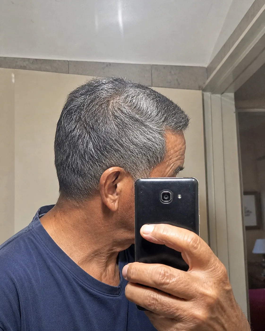 Selfie casual de un hombre mayor mostrando de costado su cabello canoso